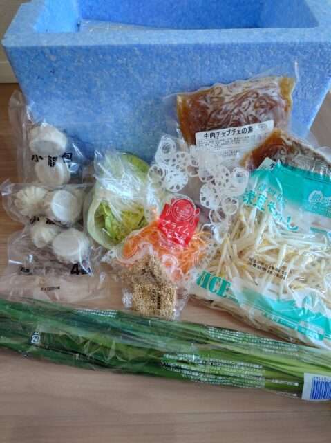 ヨシケイで届いた葉物野菜や肉などの食材の写真